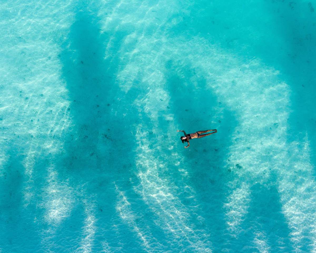 unnamed road high angle photography of woman swimming during daytime huraa